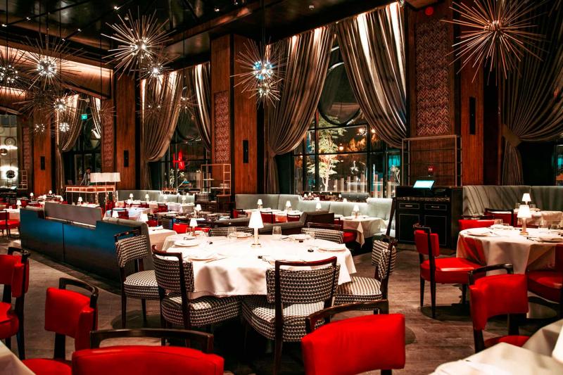 تشكل المؤثرات التصميمية والألوان الدافئة خلفية درامية للعروض الترفيهية التي يتيحها مطعم بليونير الرياض.