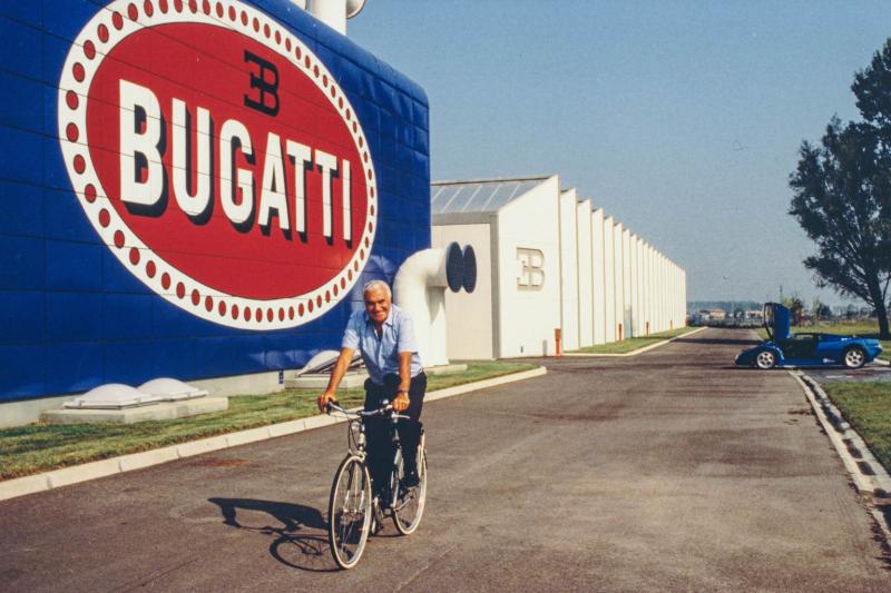 أرتيولي يركب درّاجته أمام مصنع بوغاتي.